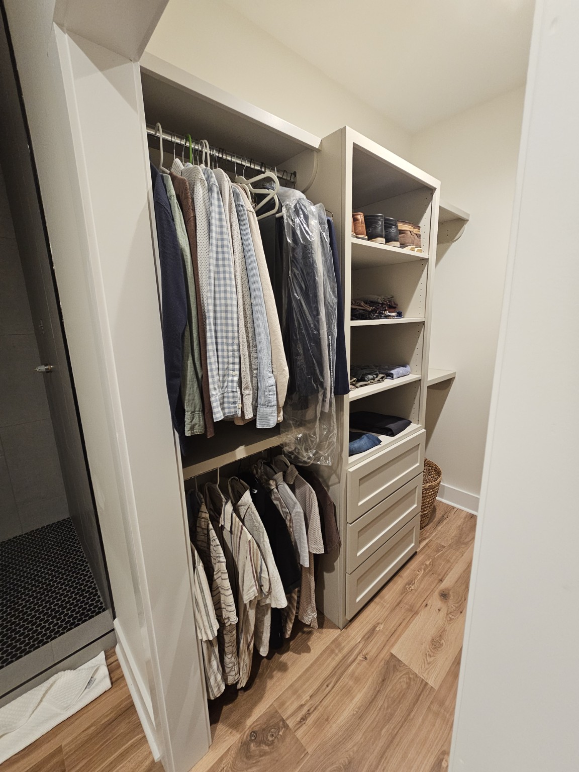 Walk-in storage with adjustable shelving and built-in drawers by Hilltop Cabinets LLC